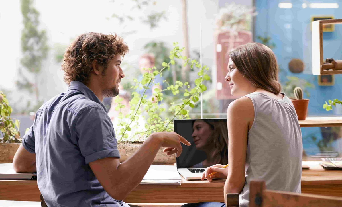 Two students practicing conversation in a relaxed setting, showcasing Berlitz english classes online focus on real-world communication skills.